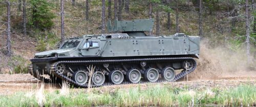 Patria TRACKX sedd från sidan på en grusväg vid en sjö